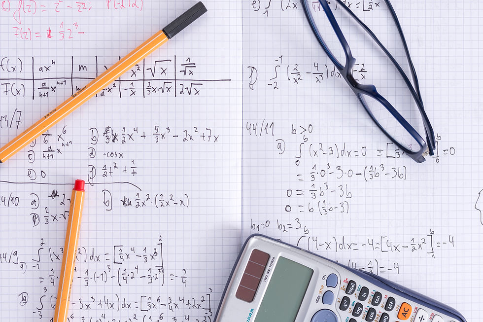 A tutor writing a maths formula on a whiteboard